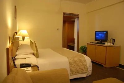 a hotel room with a bed and a television at Sandesh The Prince in Mysore
