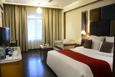 a hotel room with a large bed and a television at Sandesh The Prince in Mysore