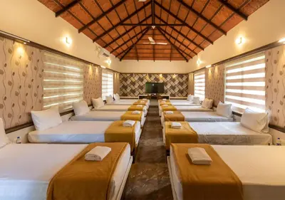 a row of beds in a room with a tv at SR Jungle Resort in Coimbatore