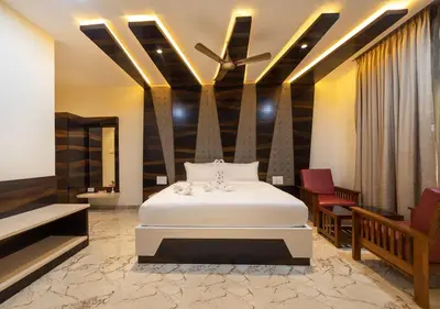 a bedroom with a white bed and two chairs at SR Jungle Resort in Coimbatore