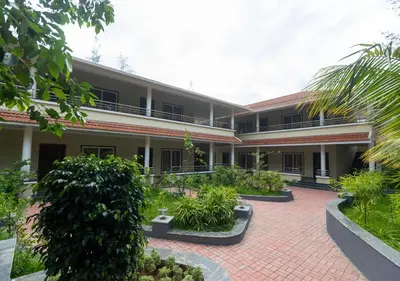 a courtyard of a building with plants and trees at SR Jungle Resort in Coimbatore