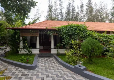 a small white house with a red roof at SR Jungle Resort in Coimbatore