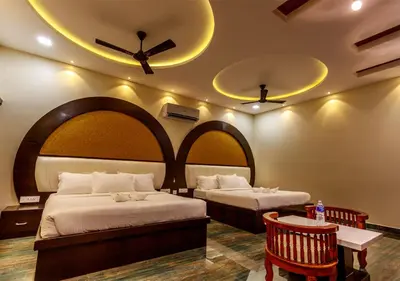 a hotel room with two beds and a ceiling fan at SR Jungle Resort in Coimbatore