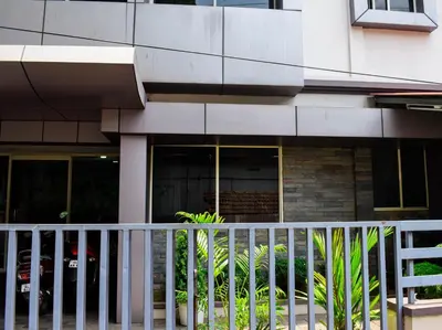 a white fence in front of a building at Ruby Residency in Kozhikode