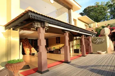 a house with a wooden porch with a roof at Silent Shores Resort & Spa in Mysore