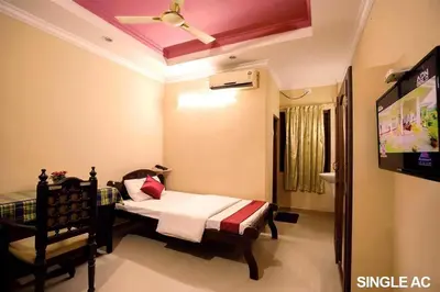 a bedroom with a bed and a tv in a room at Surabhi Suites in Angamali