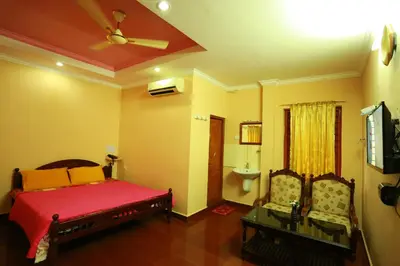 a bedroom with a bed and a ceiling fan at Surabhi Suites in Angamali