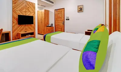 a hotel room with two beds and a tv at Treebo Vinayak Inn, 600 Mts From Coimbatore Railway Station in Coimbatore