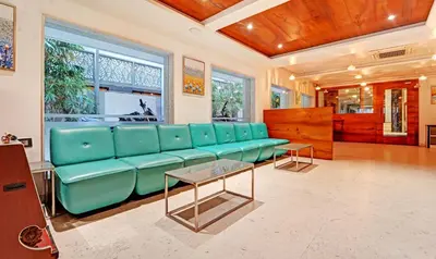 a living room with a blue couch and a table at Treebo Vinayak Inn, 600 Mts From Coimbatore Railway Station in Coimbatore