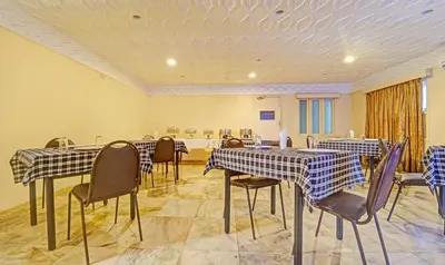 a banquet hall with tables and chairs and a room at Treebo Vinayak Inn, 600 Mts From Coimbatore Railway Station in Coimbatore