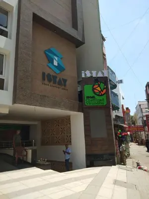 a man standing in front of a building with a sign at Hotel iStay in Coimbatore