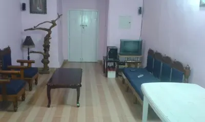 a living room with a couch and a tv at Rustling River Resort in Ooty