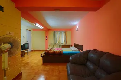 a living room with a couch and a bed in it at Rustling River Resort in Ooty