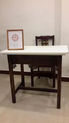 a table and a chair with a picture on it at Olives Pleasant Stays in Ooty