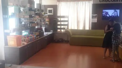 a woman is taking a picture of a store at Olives Pleasant Stays in Ooty