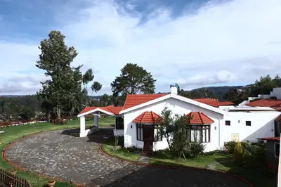 a white house with a red roof at 7 BHK Luxury Heritage Villa - Rock Ooty in Ooty