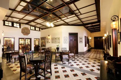 a dining room with a table and chairs at 7 BHK Luxury Heritage Villa - Rock Ooty in Ooty