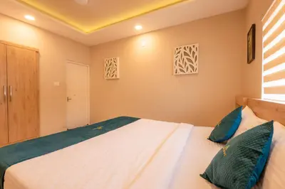 a bedroom with a large bed with blue pillows at Daan Ambalath Maple Leaves in Guruvāyūr