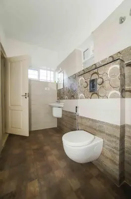 a bathroom with a toilet and a sink at Daan Ambalath Maple Leaves in Guruvāyūr