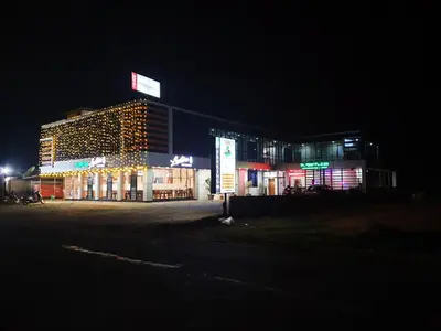 a building lit up at night with christmas lights at Paddyfield Inn in Mananthavady