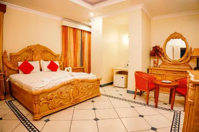 a bedroom with a bed and a table and a mirror at Emarald Resort in Pulamanthole