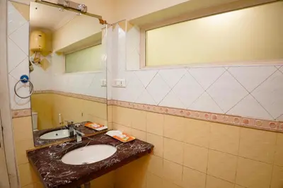 a bathroom with a sink and a mirror at Emarald Resort in Pulamanthole