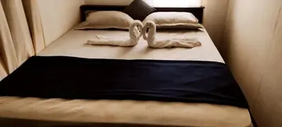a bed with two white pairs of shoes on it at family huts in Tariyod