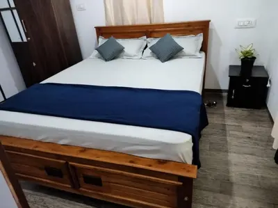 a bedroom with a large bed with a blue blanket at family huts in Tariyod