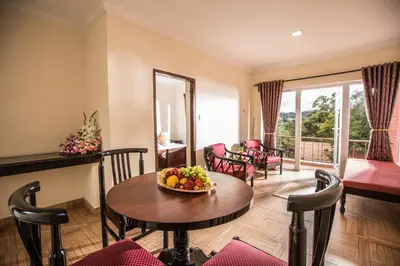 a living room with a table with a bowl of fruit on it at Hotel Lakeview in Ooty