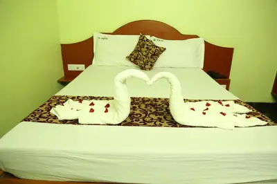 two swans made out of towels on a bed at Hotel Vijay in Pollāchi
