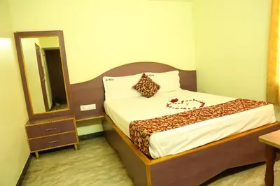 a bed in a room with a mirror and a bed sidx sidx sidx at Hotel Vijay in Pollāchi
