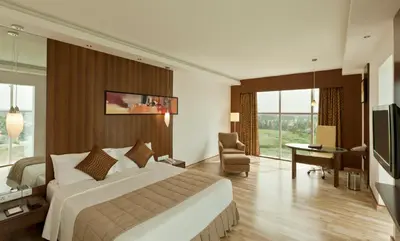 a hotel room with a large bed and a television at Gokulam Park Coimbatore in Coimbatore