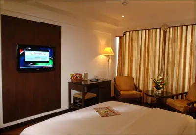 a hotel room with a bed and a television at CAG Pride in Coimbatore
