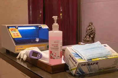 a table with a bottle of hand sanitizer and a laptop at CAG Pride in Coimbatore