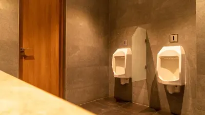 a bathroom with two urinals on the wall at CAG Pride in Coimbatore