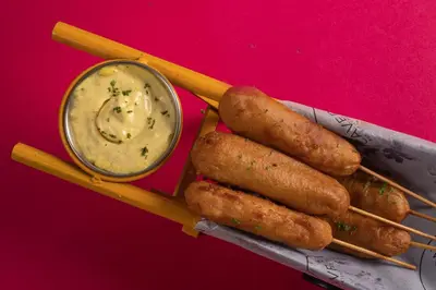 a group of carrots and chopsticks with a bowl of dip at CAG Pride in Coimbatore