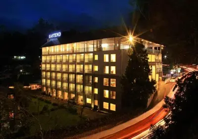a building with a sign on top of it at night at Eastend Munnar in Munnar