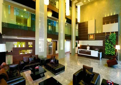 a lobby with couches and chairs in a building at Eastend Munnar in Munnar