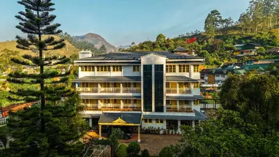 a large building in the middle of a mountain at Eastend Munnar in Munnar