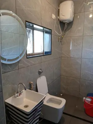 a bathroom with a sink and a toilet and a mirror at Sunset Valley Holiday Inn in Ooty