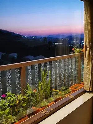 a balcony with potted plants and a view of the city at Sunset Valley Holiday Inn in Ooty