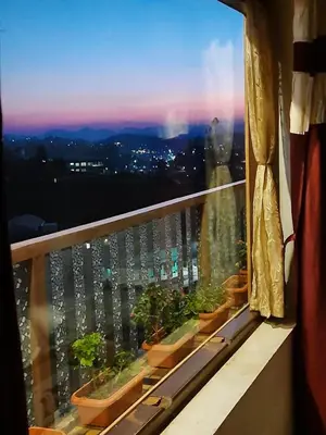 a balcony with potted plants on a window sill at Sunset Valley Holiday Inn in Ooty