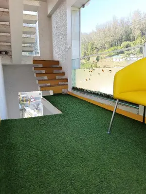 a room with a yellow chair and green carpet at Sunset Valley Holiday Inn in Ooty