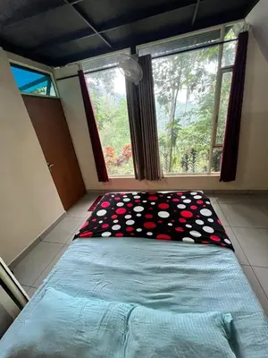 a bedroom with a bed with a pillow on it at The Hillock-quiet by the Mountains in Vallikavungal