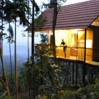 a man standing on the balcony of a house at The Hillock-quiet by the Mountains in Vallikavungal