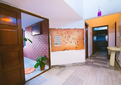 a hallway with a bathroom with a wall with a mirror at Zostel Mysore in Mysore