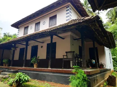 a small white house with a roof at Meadows in Trichūr