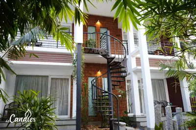 a house with a spiral staircase in front of it at Le Candles Resort in Kozhikode