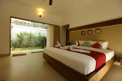 a bedroom with a large bed with a large window at Le Candles Resort in Kozhikode