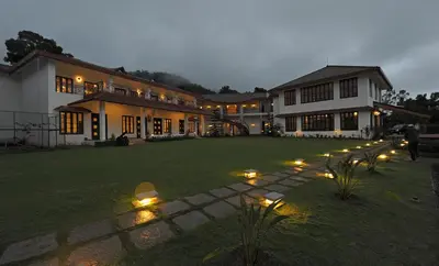 a large house with lights in the yard at Amritara Ambatty Greens Resort in Virajpet